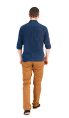 Fototapeta premium Back view of going handsome man in jeans and a shirt.