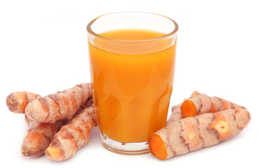 Fresh turmeric with extract in a glass