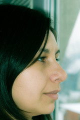 Profile portrait of a young woman by the window