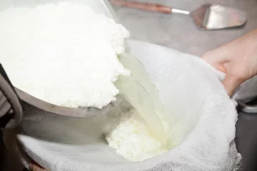 Photo sur Plexiglas Produits laitiers pouring paneer cheese in milk thrusting into gauze