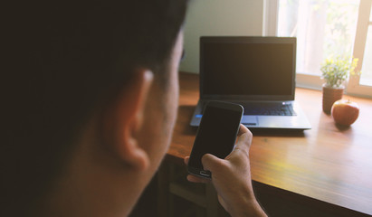 A man using smart phone and computer.