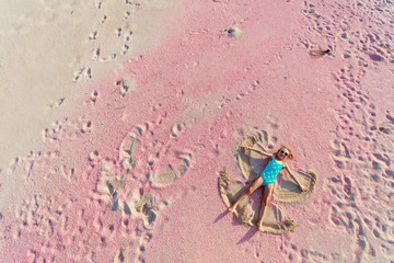 Girl making sand angel © TravelPhotoBloggers