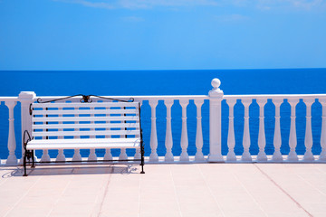 classic white balustrade, bench and empty terrace overlooking sea