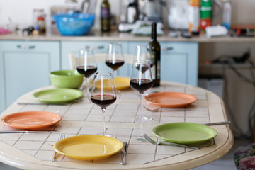 Fototapeta na wymiar Wine glasses, wine bottle and empty plates on the table