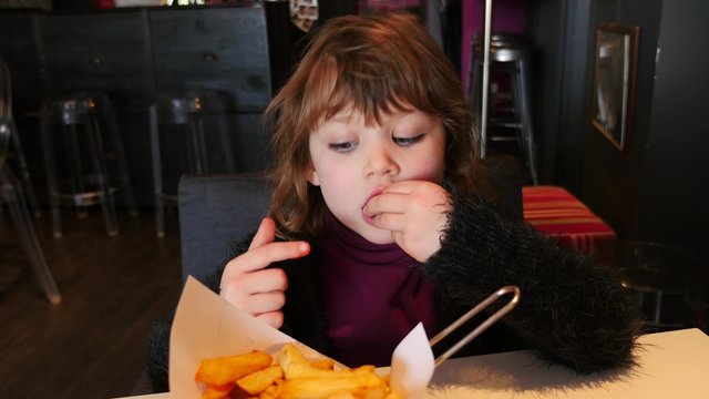 jolie enfant mangeant des frites