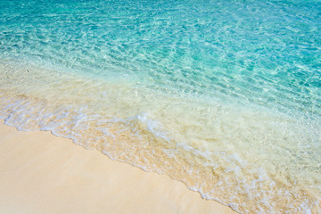 Fototapeta na wymiar Soft wave of the tropical sea on the sandy beach