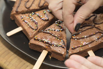 Artisan white hands preparing a sweet chocolate cake