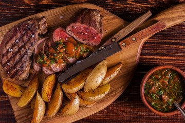 Grilled steak with potato wedges, salsa and spices.