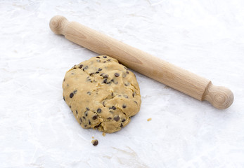 Ball of chocolate chip cookie dough with rolling pin