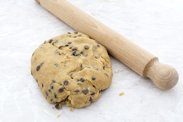 Chocolate chip cookie dough with a rolling pin