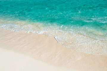 Fototapeta na wymiar Soft wave of the turquoise sea on the sandy beach. Natural summe