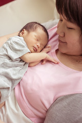 Asian mother holds her  newborn baby