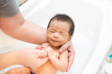 Asian newborn baby having a bath