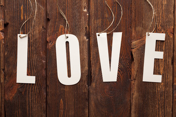Love - paper sign on wooden background