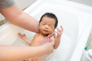 Asian newborn baby having a bath