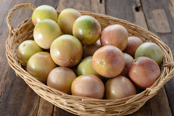 passion Fruits in the bamboo baskets on the wooden background.