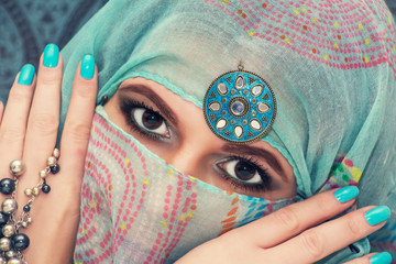 Fototapeta premium Portrait of a beautiful oriental woman in a traditional headscar