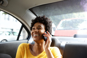 Smiling woman in a car talking on mobile phone
