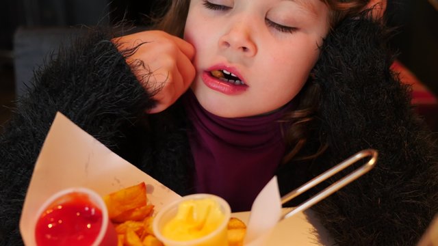 jolie enfant mangeant des frites