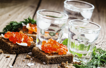 Cold Russian vodka with ice and small snacks sandwiches with but