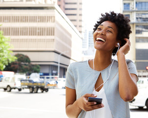 Smiling young woman listening music on headphones