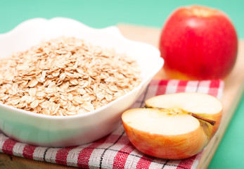 apple  with oat flakes in bowl