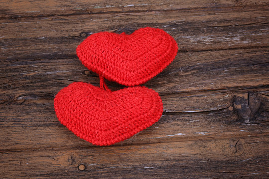 pair of knitted hearts on old wooden background Valentine's Day love handmade