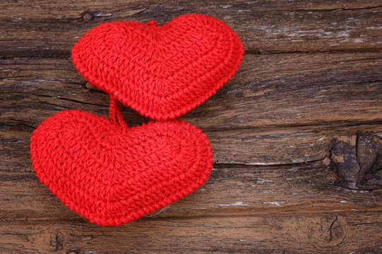 pair of knitted hearts on old wooden background Valentine's Day love handmade