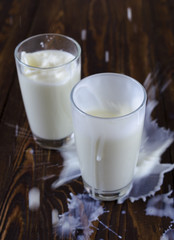 Pouring milk with cookies in the shape of a heart on a wooden background