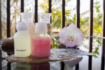 Fototapeta na wymiar Mini set of bubble bath and shower liquid gel with orchid flower