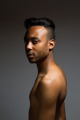 Fototapeta premium Latin man posing indoor over a grey wall.