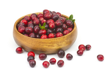 Cranberries in wooden bowl on white background.