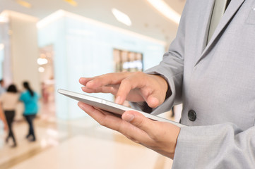 Fototapeta premium Young Man Hands holding Tablet in Shopping Mall or Department St