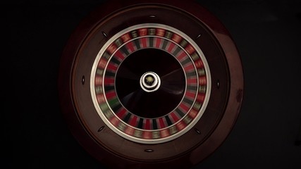 Classic roulette spinning wheel, white ball, on black