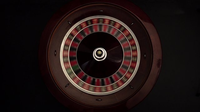 Classic roulette spinning wheel, white ball, on black