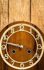 Vintage clock on wooden wall background. Concept of the passage