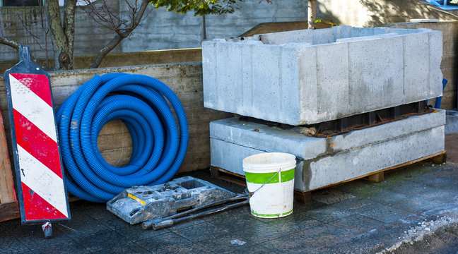 Pit precast concrete block and roll corrugated conduit deposited on a sidewalk