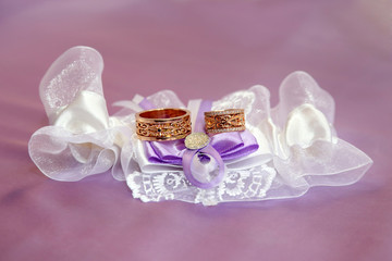 wedding rings lie on beautifully embellished fabrics