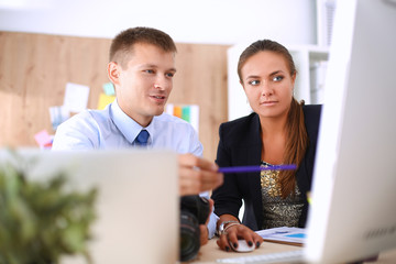 Fashion designers working in studio sitting on the desk