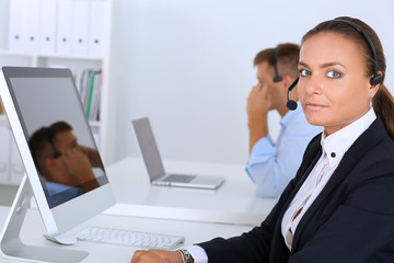 Happy female wearing headset and sitting on the desk