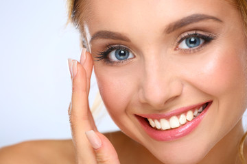 Obraz premium Young woman touching her face isolated on white background