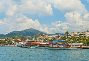 Obraz premium tourist boats at waterfront promenade on summer day