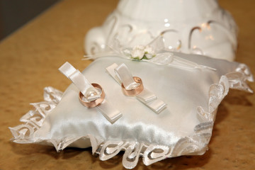 wedding rings lie on a beautiful white pillow