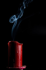 smoke goes up from the extinct red candle