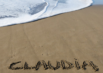 Fototapeta premium Nombre de Claudia escrito en la arena