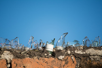 Pedazos de vidrios protegen los muros del patio de una casa.