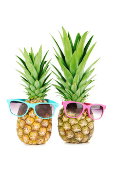 Ripe pineapples with sunglasses isolated on a white