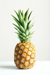 Fototapeta premium Ripe pineapple on a white wooden table