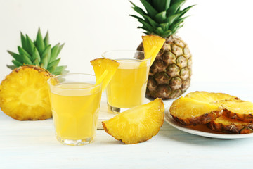 Glasses of pineapple juice on a white wooden table