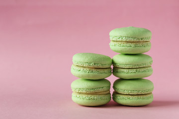 Green macarons on pink paper background